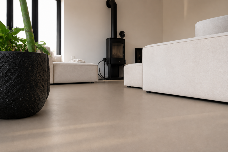 Taupe gietvloer in een woonkamer met witte bank