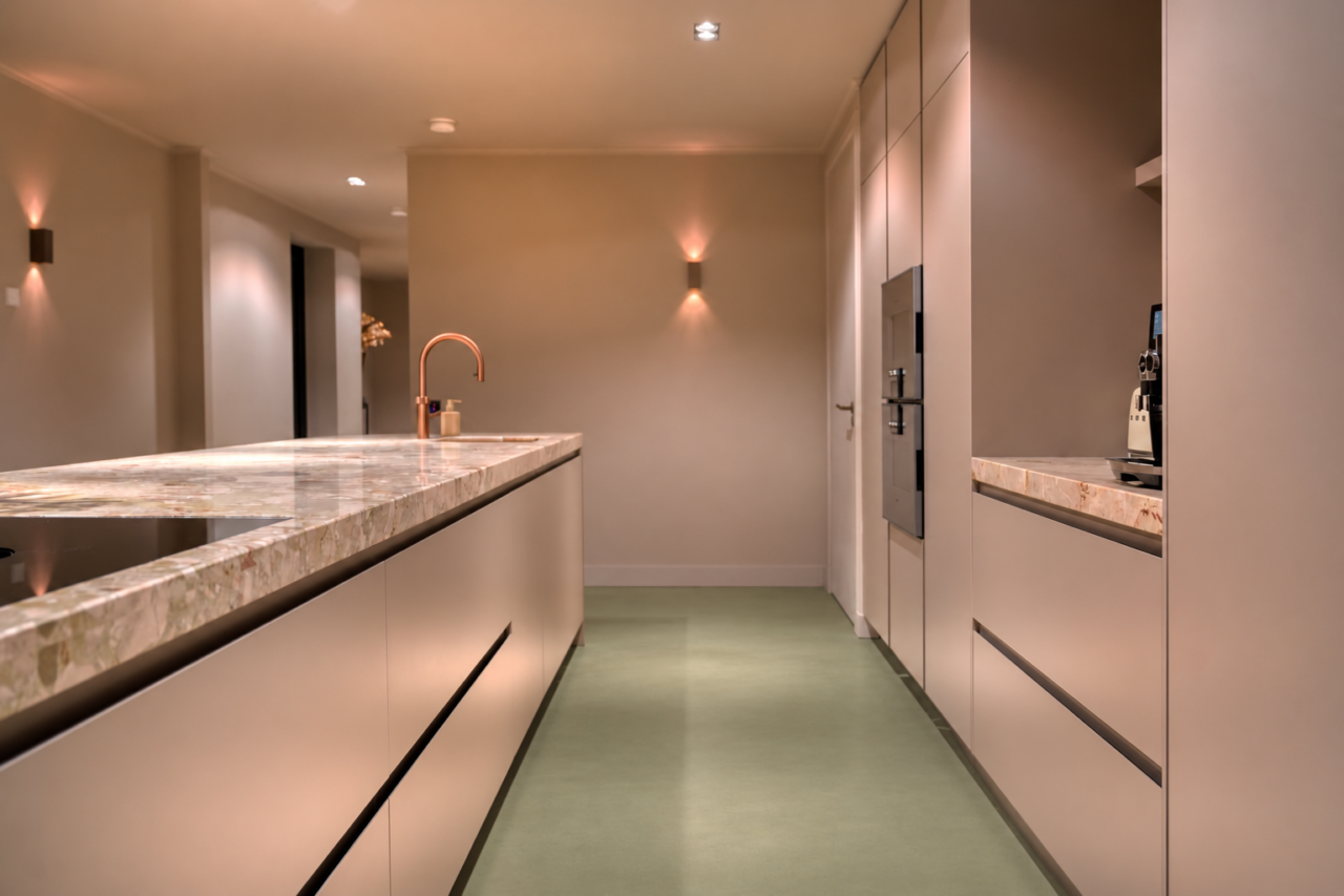 Moderne keuken met kookeiland en een naadloze groene gietvloer.